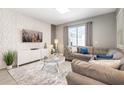 Comfortable living room featuring a plush gray sectional, textured accent wall, and bright natural light at 8993 Cabot Cliffs Dr, Davenport, FL 33896