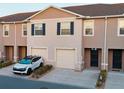Townhome featuring garage, front door, neutral stucco, small landscaped front yard, and nearby houses at 1089 Blue Jay Dr, Davenport, FL 33837