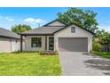 Beautiful exterior with nice landscaping, gray brick driveway, neutral colors, modern design, and covered front porch at 1109 Naples Dr, Orlando, FL 32804