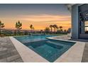 Beautiful backyard pool with integrated spa and serene waterfall feature, set against a colorful sunset at 11927 Charades St, Orlando, FL 32832