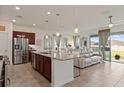 Open-concept kitchen with a large island, stainless steel appliances, and a view of the cozy living area at 125 Silver Maple Rd, Groveland, FL 34736