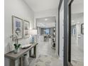 Inviting entryway with decorative console table, mirror and open floor plan beyond at 1251 Blue Daze Ln, Eustis, FL 32726