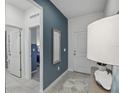 Stylish hallway featuring a blue accent wall with mirror, leading to various rooms at 1251 Blue Daze Ln, Eustis, FL 32726