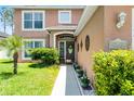 Inviting front entrance with a decorative door, manicured shrubs, and elegant exterior details at 140 Elgin Blvd, Davenport, FL 33897