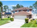 Spacious two-car garage with a driveway and lush landscaping enhancing the home's curb appeal at 140 Elgin Blvd, Davenport, FL 33897