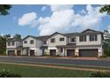 Charming row of modern townhouses with gray siding, stone accents, and attached garages at 14938 Harvest St, Orlando, FL 32824