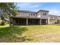Spacious backyard with a covered patio, screen enclosure, and lush green grass at 15485 Sandfield Loop, Winter Garden, FL 34787