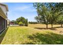 Expansive backyard featuring lush green grass and mature trees, perfect for outdoor activities and relaxation at 15485 Sandfield Loop, Winter Garden, FL 34787