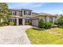 Two-story home with brick driveway and shutters; two-car garage and landscaping at 15485 Sandfield Loop, Winter Garden, FL 34787