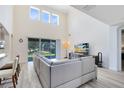 Bright living room with soaring ceilings, large windows, and a comfortable seating area at 15485 Sandfield Loop, Winter Garden, FL 34787