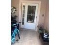 Inviting front porch with tiled flooring, potted plants, and a glass front door at 1621 Emily Ct, Kissimmee, FL 34744