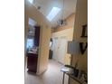 Bright hallway featuring a skylight, chandelier, tile flooring, and access to living spaces at 1621 Emily Ct, Kissimmee, FL 34744