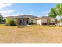 Wide view of the yard with beige home, screened lanai, and meticulous landscaping at 18920 Overton St, Orlando, FL 32833