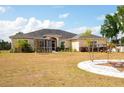 Expansive lawn surrounds the charming home with a screened lanai and paved patio area at 18920 Overton St, Orlando, FL 32833