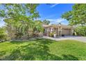Inviting single-story house featuring lush landscaping, a tiled roof, and an attached two-car garage at 196 Torino Ln, Kissimmee, FL 34759