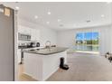 Open concept kitchen with island, stainless steel appliances, and sliding doors to a lake view at 2029 Crystal Bell St, Orlando, FL 32824