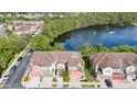 Aerial view of a charming townhome community surrounding a beautiful pond with a fountain at 2112 Rookery Ln, Sanford, FL 32773