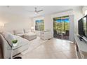 Bright living room with tiled floors, neutral decor, and sliding doors leading to the screened patio at 2112 Rookery Ln, Sanford, FL 32773