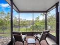 Screened patio offers tranquil view of lush greenery and a serene lake at 2112 Rookery Ln, Sanford, FL 32773