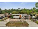 Mid-century home featuring a concrete fence, stucco walls, and orange trim, under blue skies at 2303 Bonneville Dr, Orlando, FL 32826