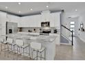 Bright kitchen featuring stainless steel appliances, white cabinetry, granite countertops, and island seating at 2382 Zaballina Pl, Kissimmee, FL 34747