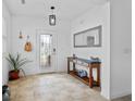 Bright foyer featuring neutral tile flooring, console table, mirror, and decorative plants at 242 Milestone Dr, Haines City, FL 33844