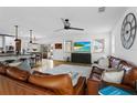 Spacious living room with comfortable leather seating, a ceiling fan and open access to other living areas at 242 Milestone Dr, Haines City, FL 33844