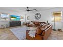 Inviting living room showcases a large brown leather couch, fan and natural light at 242 Milestone Dr, Haines City, FL 33844