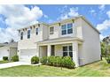 Beautiful two-story home with manicured lawn, and inviting front porch with stylish accents at 2524 Harmonia Hammock Rd, Harmony, FL 34773