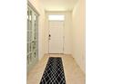 Welcoming foyer featuring neutral tile flooring and a stylish rug, setting a sophisticated tone at 2524 Harmonia Hammock Rd, Harmony, FL 34773