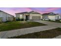 Inviting single-story home with a two-car garage and manicured lawn set against a twilight sky at 292 Spirit Landings Cir, Winter Haven, FL 33880