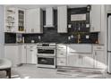Modern white kitchen with stainless steel appliances and stylish black backsplash at 302 Hermits Trl, Altamonte Springs, FL 32701