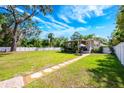 Expansive backyard featuring a stone pathway and a covered patio, perfect for outdoor entertaining at 306 Albany Ave, Deland, FL 32724