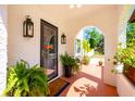 Inviting front porch with potted plants, sconces, and a decorative archway at 306 Albany Ave, Deland, FL 32724
