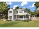 Classic two-story home with a spacious front porch and beautifully landscaped yard at 32615 Windy Oak St, Sorrento, FL 32776