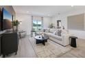 Inviting living room with a large sectional sofa, neutral tones, and a view of the outdoors at 3588 Dahlia Dr, Haines City, FL 33844