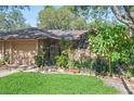 Landscaped front yard with green grass, garden beds, and a charming brick and gated entrance at 396 Newton, Longwood, FL 32779