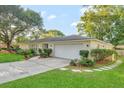Charming single-story home with an attached garage, mature trees, and a long concrete driveway at 4011 Teriwood Ave, Orlando, FL 32812