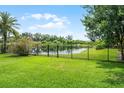 Lush backyard with a black metal fence and scenic water views at 408 Egret Place Dr, Winter Garden, FL 34787
