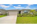 Well-manicured lawn and tasteful landscaping enhance the curb appeal of this lovely home at 415 Overpool Ave, Davenport, FL 33896