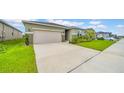 Charming single-Gathering home with lush landscaping, a well-maintained lawn, and a spacious driveway at 415 Overpool Ave, Davenport, FL 33896