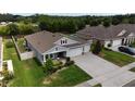 An elevated view of a lovely single-Gathering home featuring a three-car garage, a well-kept yard, and a covered entryway at 449 Halter Dr, Apopka, FL 32712