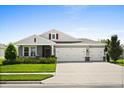 Well-maintained single-Gathering home with a green lawn and a three-car garage at 449 Halter Dr, Apopka, FL 32712