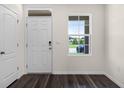 Bright entryway featuring a white front door, sidelight window, and wood-look flooring at 5217 Marshelder St, Apopka, FL 32712