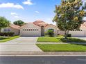 Inviting single-story home featuring a lush front lawn, mature landscaping, and a two-car garage at 5337 Watervista Dr, Orlando, FL 32821