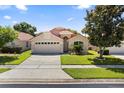 Lovely single-story home with a well-maintained lawn, mature tree, and an attached two-car garage at 5337 Watervista Dr, Orlando, FL 32821