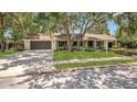 Beautiful single-story home with a spacious driveway, manicured lawn, and mature trees at 702 N Sweetwater Blvd, Longwood, FL 32779