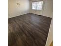 An empty bedroom with dark brown floors, a window and a white door and closet at 710 Ridenhour Cir # 710, Orlando, FL 32809