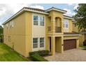 Side view of a two-story home with a brown garage door and manicured landscaping at 7519 Marker Ave, Kissimmee, FL 34747