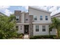 Stylish two-story home with a stone accent wall and modern design elements, showcasing curb appeal at 780 Drop Shot Dr, Davenport, FL 33896
